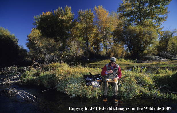 Angler tying a fly for the hatch of the day