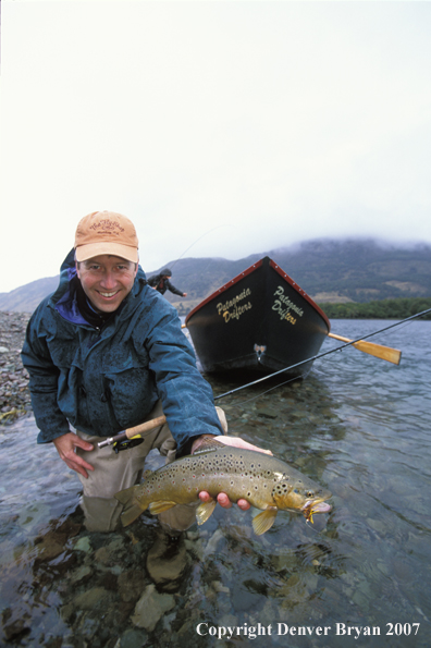 Flyfisherman holding brown trout.