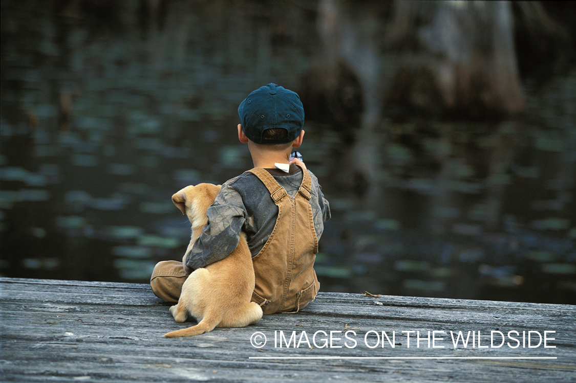 Young hunter with yellow Lab pup.