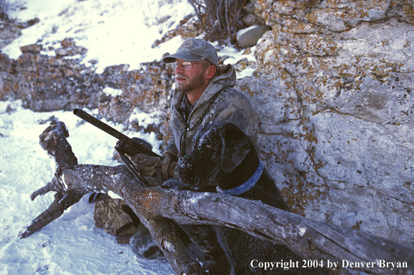 Waterfowl hunter with black Lab.