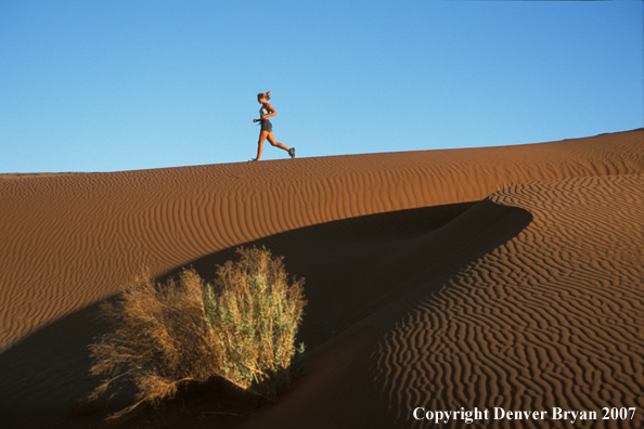 Woman running on sand dunes in Sossusvlei park, Namibia. Africa