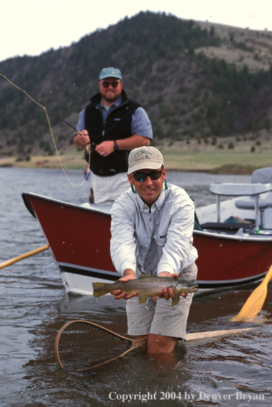 Flyfisherman holding brown trout.