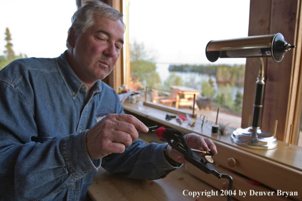 Flyfisherman tying flies at lodge (MR).