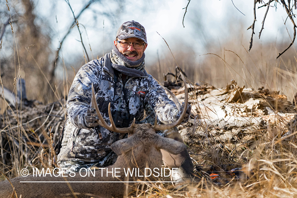 Bowhunter with bagged white-tailed buck. 