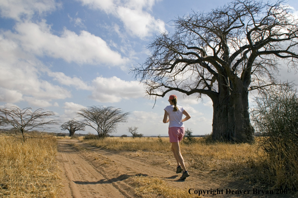 Woman jogging in Tarangire National Park, Tanzania, Africa