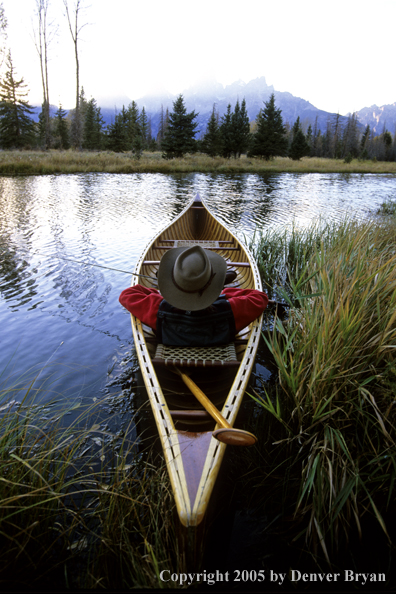 Flyfisherman with Golden Retriever in wooden cedar canoe.  