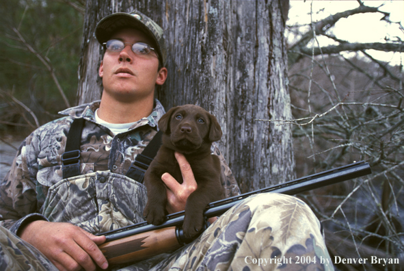 Waterfowl hunter with chocolate Lab pup.