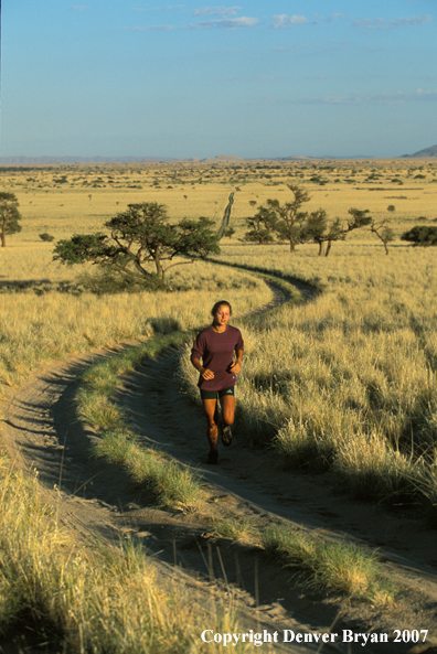 Woman running on road, Namibia. Africa.