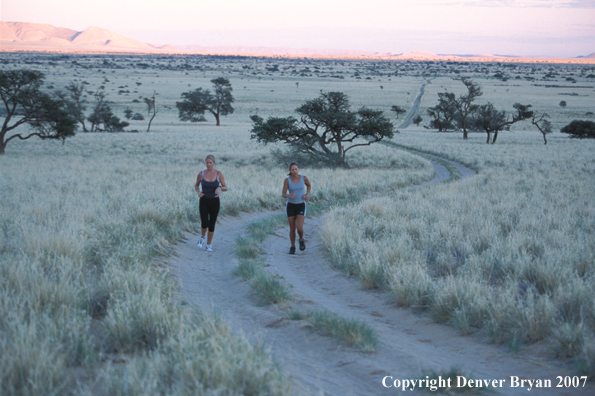 Women running on road, Namibia. Africa.