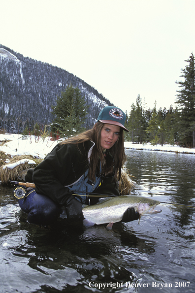 Woman flyfisher with rainbow trout.