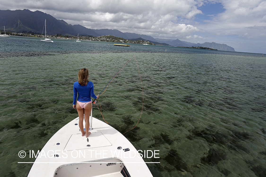 Woman flyfishing on flats boat in saltwater. 