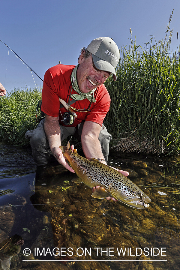 Flyfisherman with brown trout. (HDR)