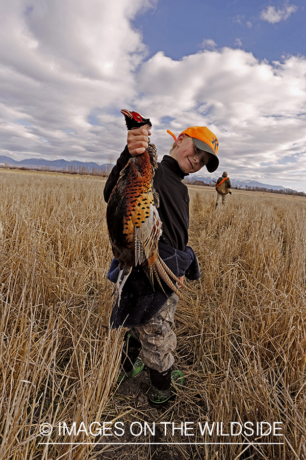 Young hunter with bagged pheasant. 