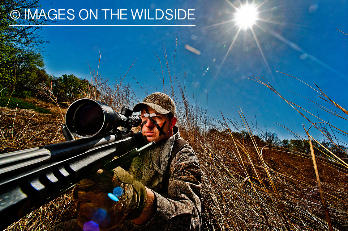 Hunter with AR15 rifle in field. 