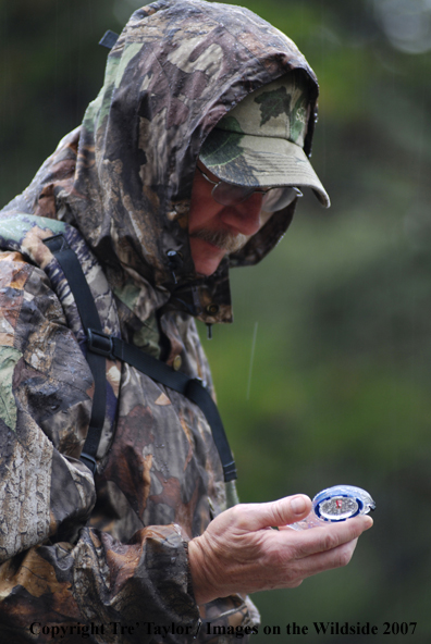 Bowhunter looking at compass