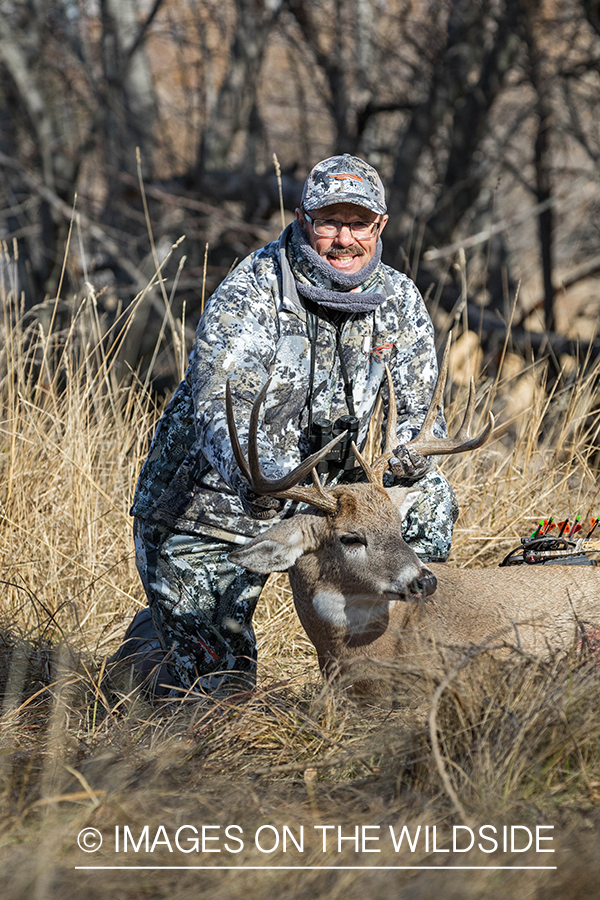 Bowhunter with bagged white-tailed buck. 