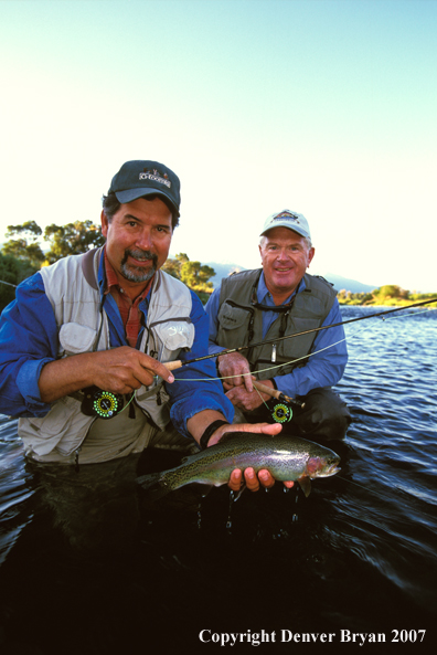 Flyfisherman holding rainbow trout.