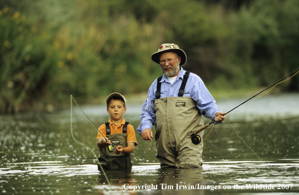 Grandfather teaching grandson how to fish