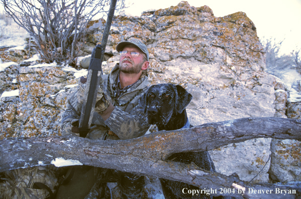 Waterfowl hunter with black Lab.