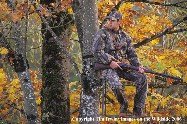 Muzzleloader hunter sitting in tree stand.