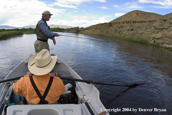 Flyfishermen fishing river from drift boat.