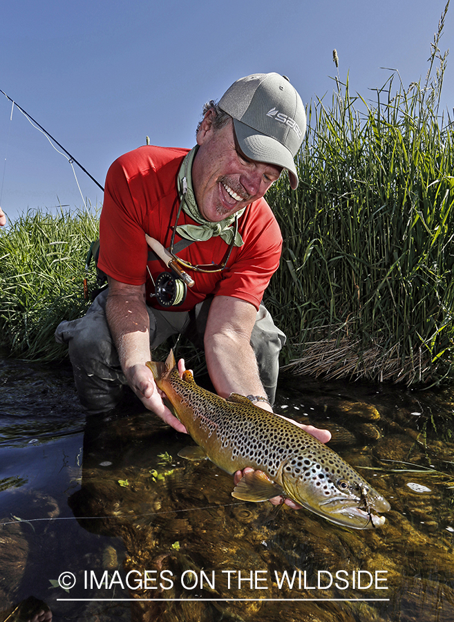 Flyfisherman with brown trout. (HDR)