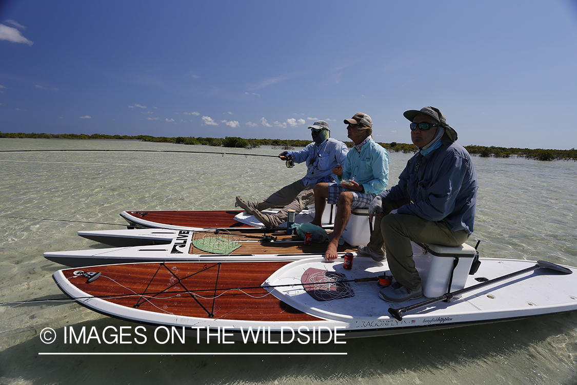 Flyfishermen having lunch on stand up paddle boards.