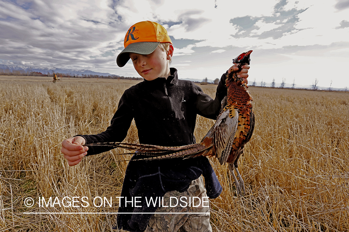 Young hunter with bagged pheasant. 