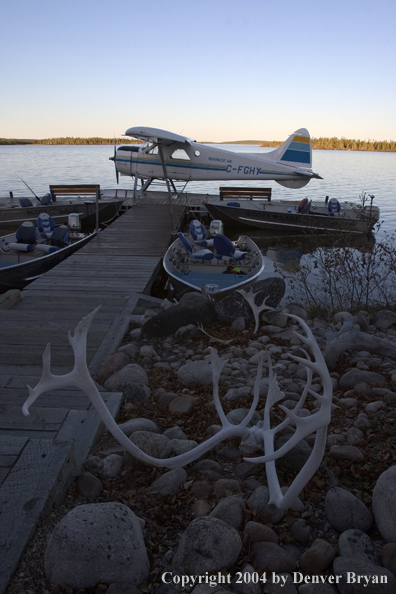 Float plane and fishing boats tied up to the dock at dusk.  Saskatchewan.