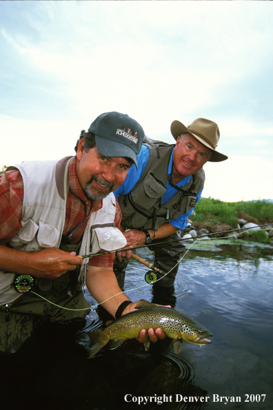 Flyfisherman holding brown trout.