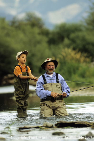 Grandfather teaching grandson how to fish