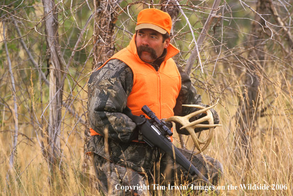 Deer hunter rattling white-tailed bucks into range for a slug gun.