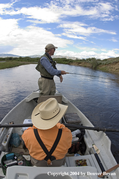 Flyfishermen fishing river from drift boat.