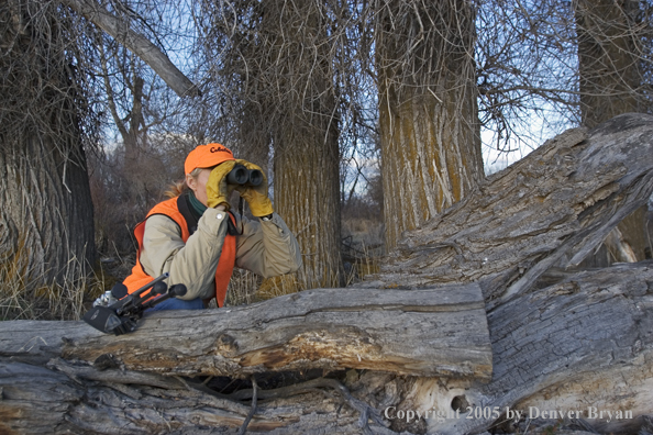 Woman big game hunter glassing for game.