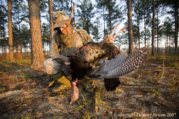 Turkey hunter in field with bagged bird