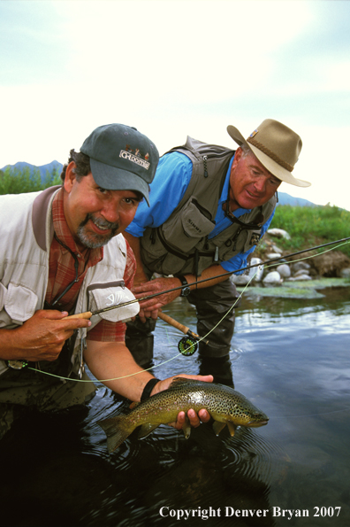 Flyfisherman holding brown trout.