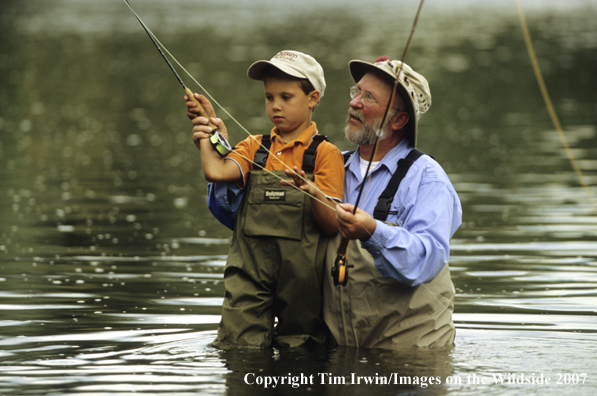 Grandfather teaching grandson how to fish