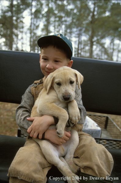 Young hunter with yellow Lab pup.