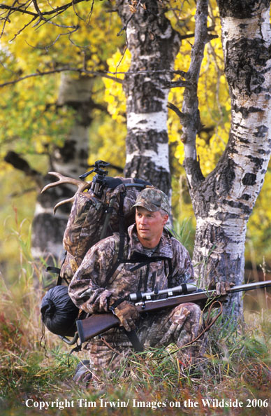 In-line muzzleloader hunter packing caped out mule deer.