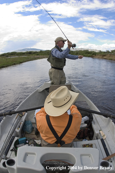 Flyfishermen fishing river from drift boat.