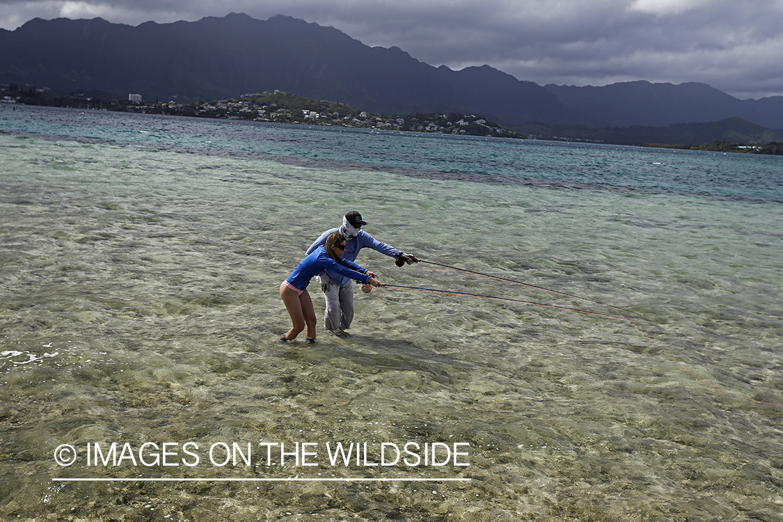 Woman flyfishing in saltwater with guide.