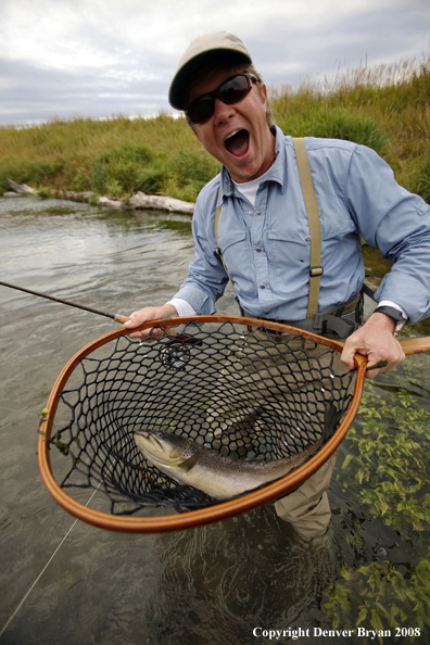 Flyfisherman with brown trout in net