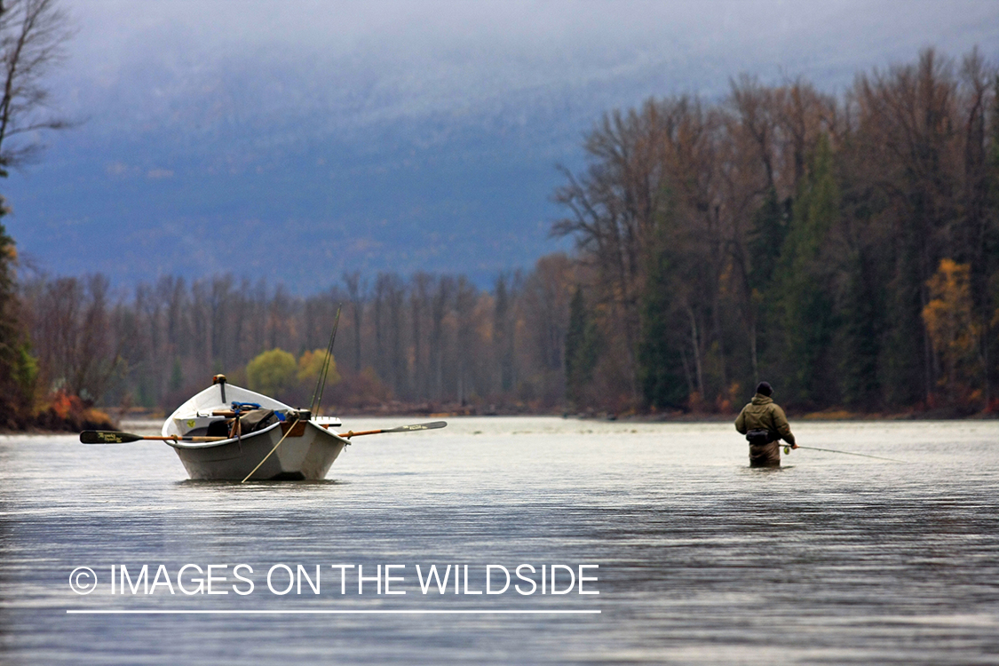 Flyfisherman and boat on river. 