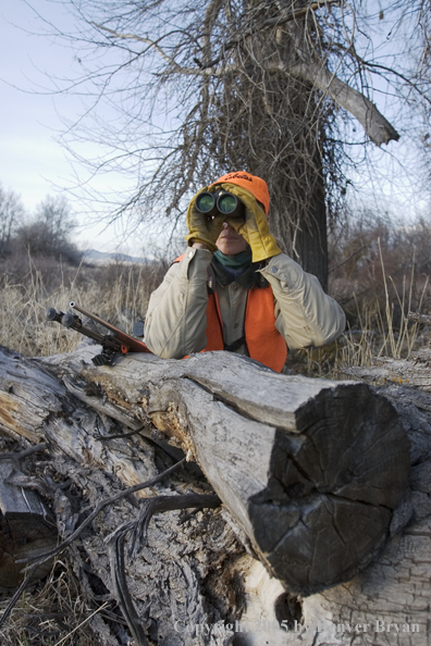 Woman big game hunter glassing for game.