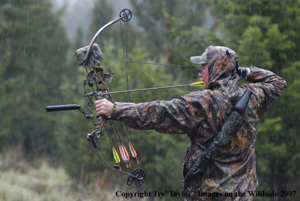 Bowhunter drawing back bow