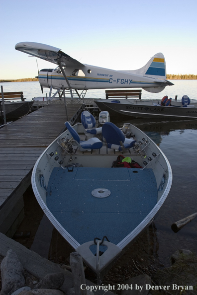 Float plane and fishing boats tied up to the dock at dusk.  Saskatchewan.