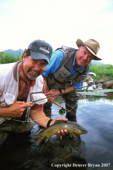 Flyfisherman holding brown trout.