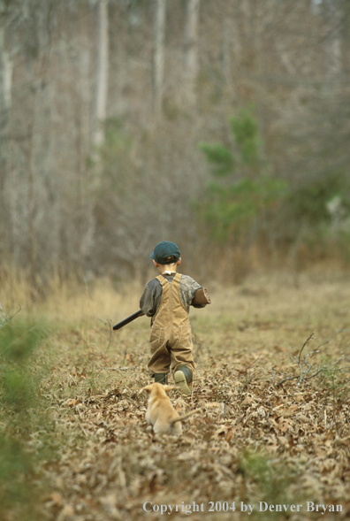 Young hunter with yellow Lab pup.