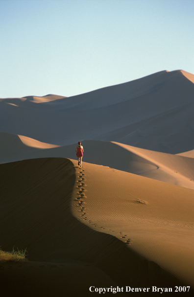 Woman running on sand dunes in Sossusvlei park, Namibia. Africa