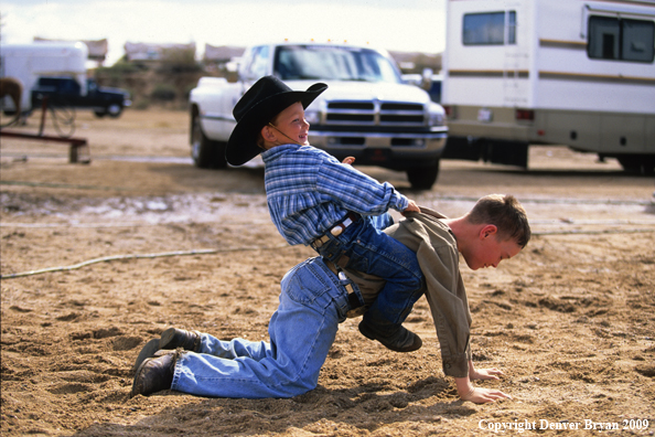 Young cowboys playing horse at rodeo